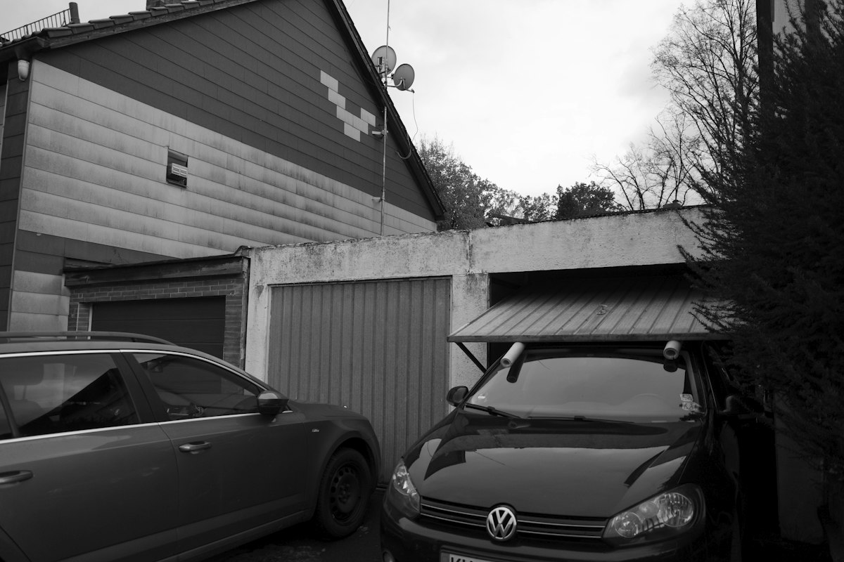 Cars parked in front of a row of small garages