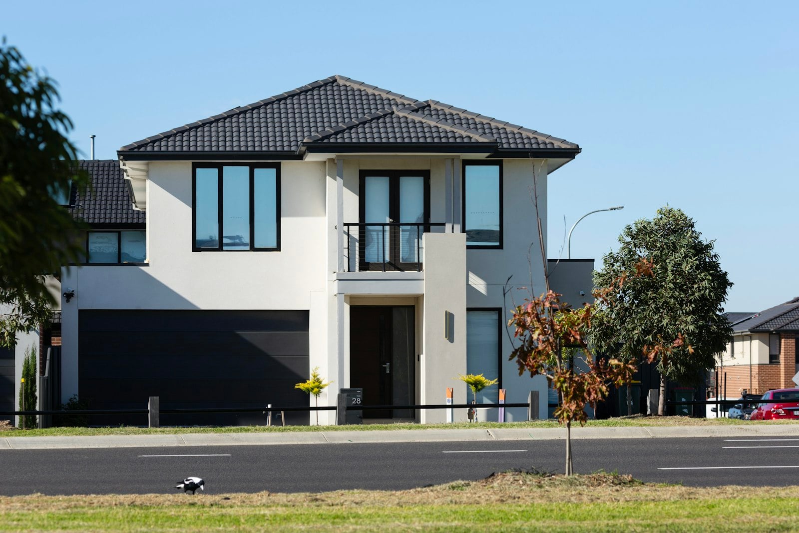 Two-story home with a wide dark garage door