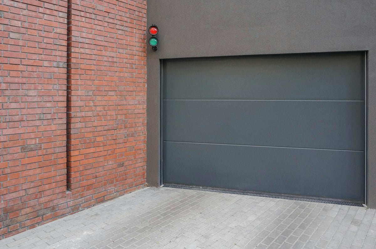 Gray sectional garage door beside brickwork