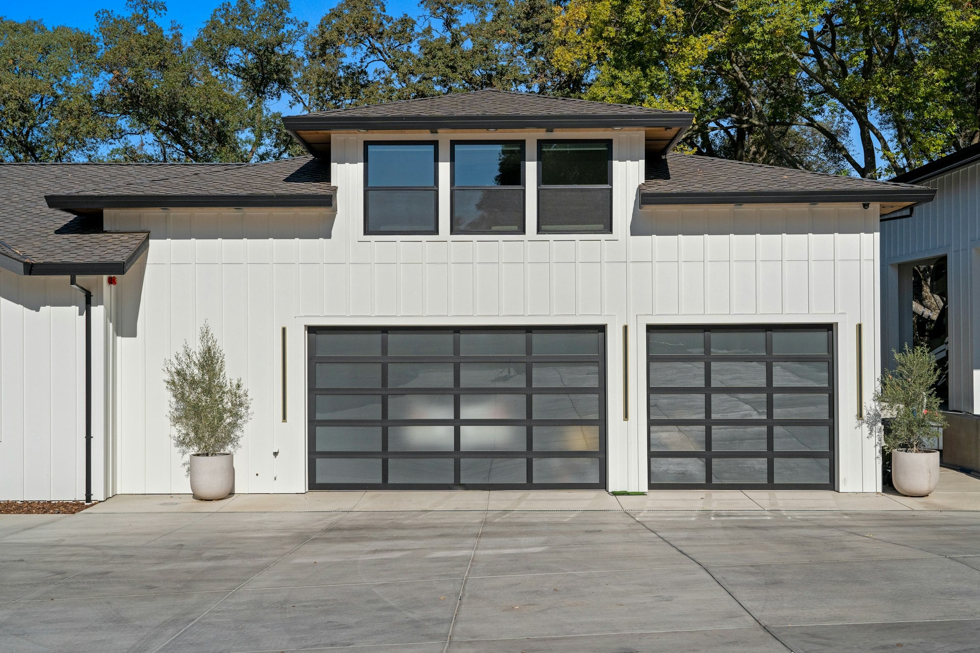 Two glass-panel garage doors on a white modern home