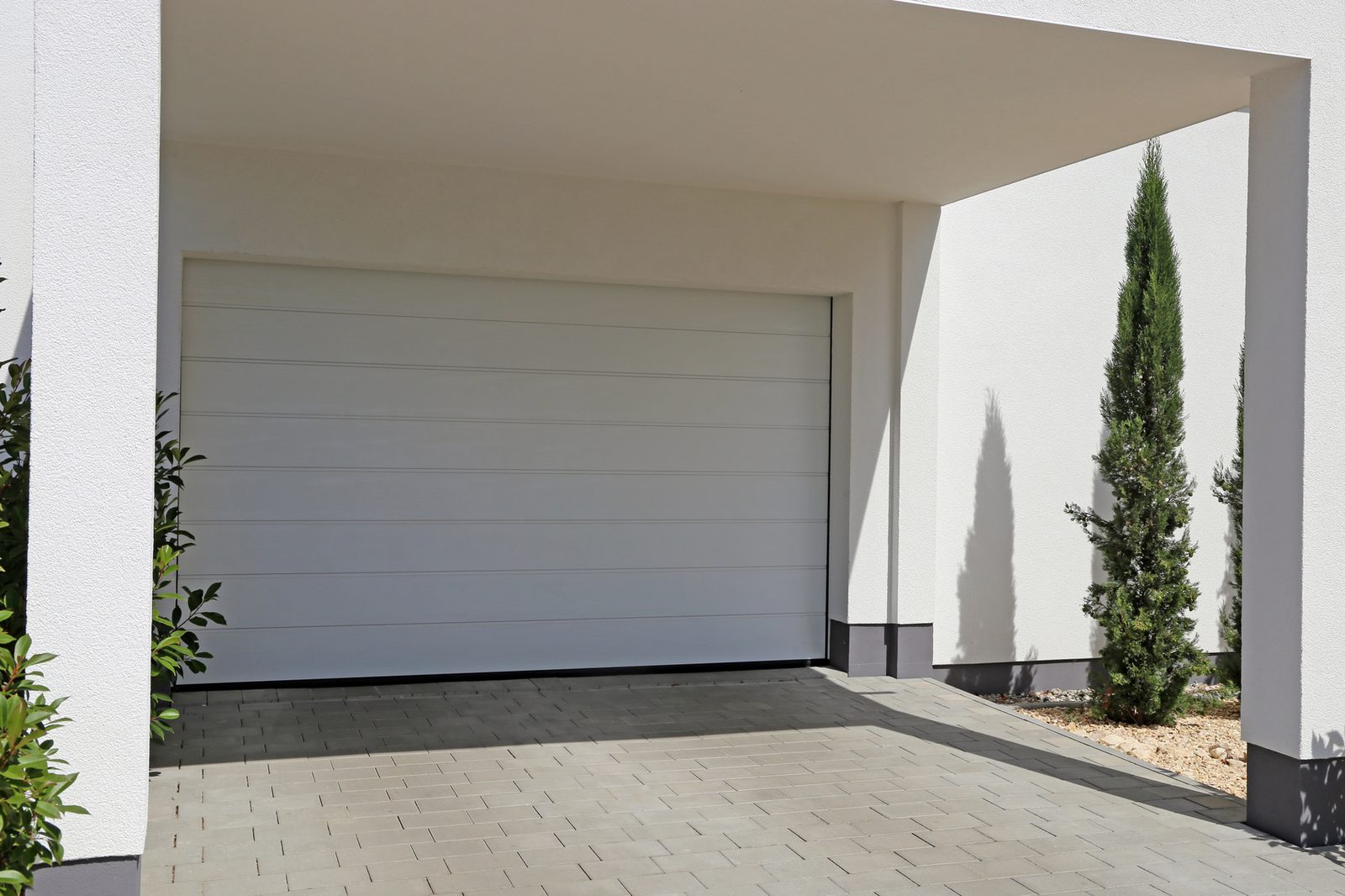 White sectional garage door under a covered modern carport